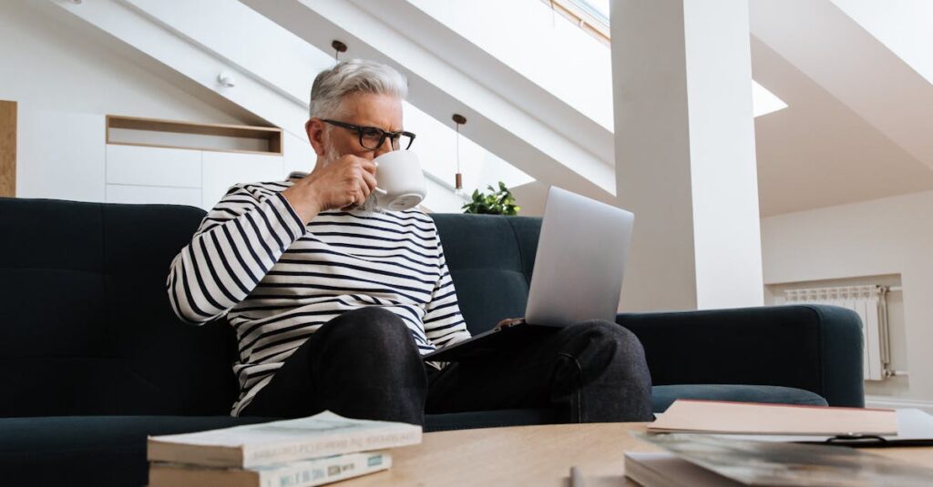 シニアが自宅でパソコンを使って副業をしているリラックスした様子