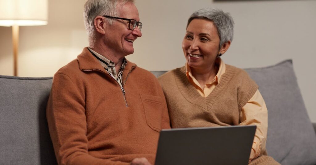 シニアが自宅のソファでスマホを使ってアンケートに答えている様子