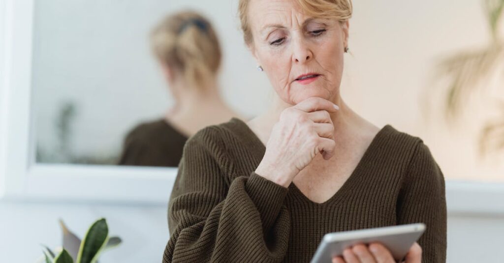 シニアが自宅のソファでスマホを使ってアンケートに答えている様子