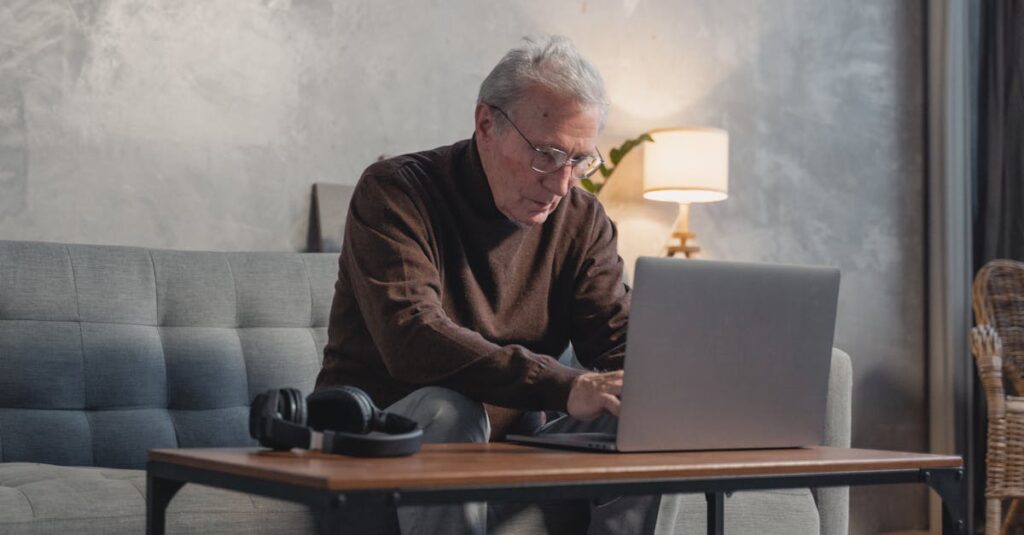 50代・60代のシニアが自宅で落ち着いてノートパソコンを使い、在宅副業に取り組んでいるイメージ